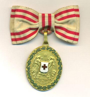 Obverse view of medal. Red Cross 50th Anniversary 1864-1914 Medal. Gilt with wreath, mounted on Ladies bow riband.